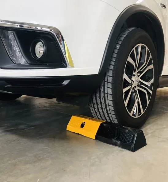 Tope de parking negro con bandas amarillas detrás de la rueda de un coche